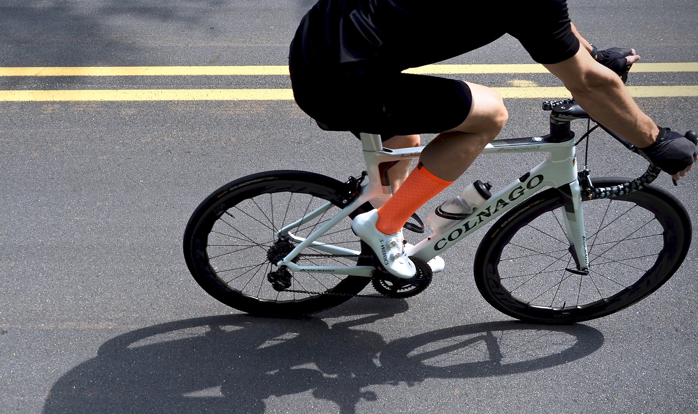 Cyclist on road bike wearing brightly colored EVO Mont Ventoux lightweight printed cycling socks